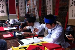 Ngày càng có nhiều thầy đồ trẻ tại "phố ông đồ" Văn Miếu. (Ảnh: Hồng Kiều/Vietnam+)