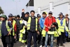 Những người lao động Việt Nam từ Libya phấn khởi về đến sân bay Nội Bài an toàn. (Ảnh: Hữu Việt/TTXVN)