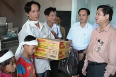 Giám đốc Sở LĐTBXH tỉnh Hà Tĩnh trao quà cứu trợ cho gia đình ông Đặng Hữu Ký. Ảnh: Xuân Dũng (Vietnam+)