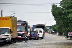 Nước lũ tràn qua Quốc lộ 1A. (Ảnh: Trần Tính/TTXVN)