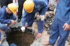 Công nhân tiến hành khắc phục sự cố sụt lún mặt đường. (Ảnh: Hoàng Tuấn/TTXVN)