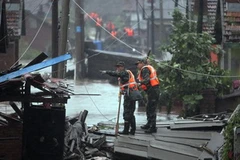 Nhân viên cứu hộ tìm cứu nạn nhân lũ lụt do bão Utor. (Nguồn: AFP/TTXVN)