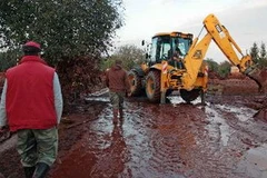 Người dân xúc bùn ra khỏi nhà. (Nguồn: AFP/TTXVN)