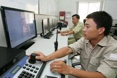 Kiểm tra mức nước hồ thủy điện Buôn Kuốp. (Ảnh: Ngọc Hà/TTXVN)