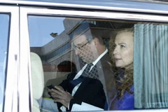 Tổng thống François Hollande cắm cúi vào một chiếc điện thoại giống như iPhone.