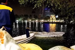 Chuẩn bị bãi cát nhân tạo dưới chân tháp Rùa để đón "cụ" Rùa lên chữa bệnh. (Ảnh: Quý Trung/TTXVN)