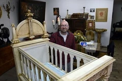 Thợ điêu khắc Dariusz Bergier cùng chiếc nôi. (Nguồn: AFP)