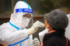 Nhân viên y tế lấy mẫu xét nghiệm COVID-19 cho người dân tại tỉnh Cam Túc, Trung Quốc. (Ảnh: AFP/TTXVN)