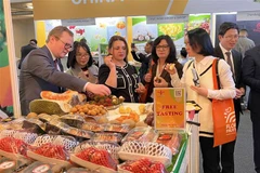 Các khách hàng quốc tế thưởng thức hoa quả Việt Nam tại Fruit Logistica 2023. (Ảnh: Phương Hoa/TTXVN)