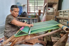Nghệ nhân lớn tuổi người Chăm dệt vải thổ cẩm truyền thống. (Ảnh: Nguyễn Thành/TTXVN)