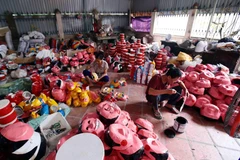 Mặt nạ được những nghệ nhân tỉ mẩn vẽ mô phỏng lại các nhân vật dân gian. (Ảnh: Phạm Kiên/TTXVN)