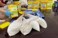 Cơ quan chức năng đang kiểm tra các hộp cacao nghi vấn và phát hiện các gói tinh thể màu trắng. (Nguồn: Báo Điện tử Chính phủ)