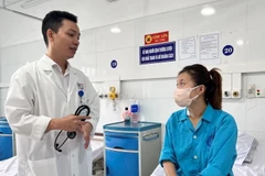 Bác sỹ thăm khám bệnh nhân sau ca phẫu thuật. (Ảnh: TTXVN phát)