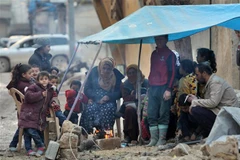 Người dân đốt lửa sưởi ấm trong thời tiết giá lạnh do bị mất nhà cửa sau trận động đất tại Jindayris, Syria, ngày 7/2/2023. (Ảnh: AFP/TTXVN)