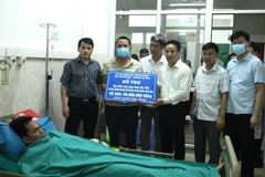 Ông Nguyễn Thế Bình, Giám đốc Sở GD&ĐT Hà Giang trao 50 triệu đồng của Quỹ khuyến học khuyến tài tỉnh Hà Giang hỗ trợ gia đình thầy Nam. (Ảnh: Minh Tâm/TTXVN)