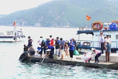 Thả các cá giống, hải sâm cát xuống biển vịnh Nha Trang. (Ảnh: Tiên Minh/TTXVN)