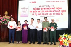 Ông Nguyễn Trọng Nghĩa, Bí thư Trung ương Đảng, Trưởng Ban Tuyên giáo Trung ương tặng sách cho các đơn vị. (Ảnh: Phương Hoa/TTXVN)