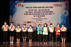 Trao học bổng cho các em học sinh bị ảnh hưởng do đại dịch COVID-19. (Ảnh: Hồng Giang/TTXVN)