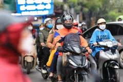 Người dân phải mặc ấm khi ra đường. (Ảnh: Thanh Tùng/TTXVN)