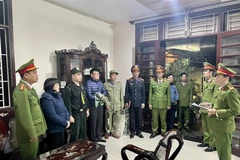 Lực lượng công an đọc lệnh bắt giữ các đối tượng. (Ảnh: TTXVN phát)