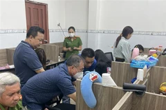 Công an khám xét căn nhà các đối tượng dùng làm nơi đòi nợ thuê. (Ảnh: TTXVN phát)