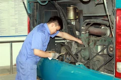 Đăng kiểm viên kiểm tra động cơ xe ôtô. (Ảnh: Nguyễn Lành/TTXVN)