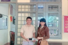 Anh Khánh trao trả tài sản nhặt được cho chị Vân. (Ảnh: TTXVN phát)