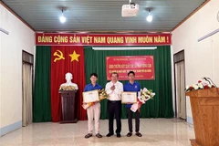 Chủ tịch UBND thành phố Gia Nghĩa Đỗ Tấn Sương (giữa) trao Giấy khen cho 2 thanh niên dũng cảm cứu người. (Ảnh: TTXVN phát)