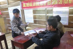 Cán bộ xã Măng Cành, huyện Kon Plông phát tài liệu tuyên truyền về động đất cho người dân. (Ảnh: Dư Toán/TTXVN)