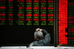 Nhà đầu tư theo dõi bảng chỉ số chứng khoán tại Bắc Kinh, Trung Quốc. (Ảnh: AFP/TTXVN)