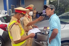 Lực lượng Cảnh sát Giao thông Công an tỉnh Sóc Trăng kiểm tra nồng độ cồn tại tuyến Quốc lộ Nam sông Hậu. (Ảnh: TTXVN phát)