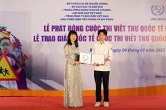 Ban tổ chức trao Giải Khuyến khích quốc tế cuộc thi viết thư quốc tế UPU lần thứ 51 (2022) cho em Nguyễn Bình Nguyên, học sinh lớp 9A1, trường THCS Nguyễn Tri Phương, quận Ba Đình, thành phố Hà Nội. (Ảnh: Lê Ngọc Phước/TTXVN)