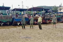 Lực lượng chức năng trên đảo Cô Tô kêu gọi người dân đưa tàu thuyền vào nơi trú ẩn an toàn. (Ảnh: Trung Nguyên/TTXVN)