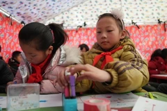 Học sinh tại một lớp học dã chiến ở khu vực chịu ảnh hưởng của động đất, huyện Tích Thạch Sơn, tỉnh Cam Túc, Trung Quốc, ngày 25/12/2023. (Ảnh: THX/TTXVN)