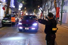 Cán bộ, chiến sỹ tổ công tác Y14/141 kiểm tra nồng độ cồn tài xế ôtô tại tuyến phố Tràng Thi-Quán Sứ. (Ảnh: Phạm Kiên/TTXVN)