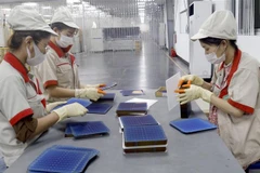 Công nhân Công ty cổ phần Vietnam Sunegry tại Khu công nghiệp Đình Trám, Bắc Giang trong dây chuyền sản xuất tấm pin năng lượng Mặt Trời. (Ảnh: Đồng Thúy/TTXVN)