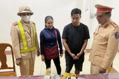 Lái xe Nguyễn Thái Phong (30 tuổi) và chủ phương tiện Nguyễn Thị Loan (52 tuổi) cùng tang vật. (Ảnh: TTXVN phát)