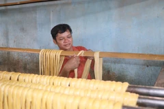 Người thợ phơi cọng tàu hũ ky trên giàn. (Ảnh: Lê Thúy Hằng/TTXVN)
