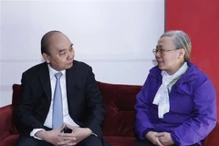 Chủ tịch nước Nguyễn Xuân Phúc và gia đình cố Chủ tịch nước Tôn Đức Thắng. (Ảnh: Thống Nhất/TTXVN)