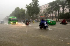 Nhiều tuyến đường thành phố Vinh bị ngập sâu khiến các phương tiện tham gia giao thông gặp nhiều khó khăn trong trận mưa sáng 16/10. (Ảnh: Tá Chuyên/TTXVN)