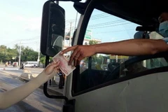 Lái xe sử dụng tiền lẻ mua vé qua trạm BOT tuyến tránh thành phố Biên Hòa. (Ảnh: Sỹ Tuyên/TTXVN)