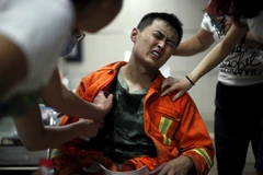 Một người lính cứu hỏa đang được sơ cứu ở bệnh viện sau vụ nổ ở Thiên Tân. (Nguồn: Reuters)