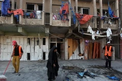 Nhân viên dọn dẹp sau vụ đánh bom ở quận Bayaa. (Nguồn: AFP/TTXVN) 