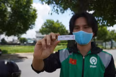 Đối tác tài xế của Gojek hào hứng khoe kết quả âm tính khi xét nghiệm nhanh COVID-19. (Ảnh: T.U/Vietnam+)