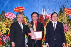 Đại diện Hội đồng chức danh giáo sư nhà nước trao chứng nhận cho các tân giáo sư, phó giáo sư. (Ảnh: Quý Trung/TTXVN)