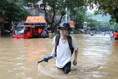 Thí sinh Hà Giang vượt lũ đến trường thi. (Ảnh: Minh Tâm/TTXVN)