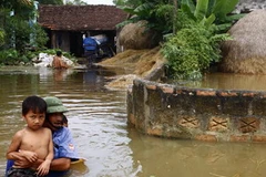 Dân quân xã Văn Sơn, huyện Triệu Sơn, Thanh Hóa đưa các cháu nhỏ đến khu vực an toàn. (Ảnh: Đình Huệ/TTXVN)