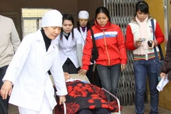 Một học sinh trường Trung học cơ sở Quán Toan được đưa đến bệnh viện (Ảnh: Vũ Văn Đức/Vietnam+)