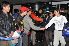 Niềm vui của người lao động khi gặp người thân ra đón tại sân bay Nội Bài. (Nguồn: Hữu Việt/TTXVN)