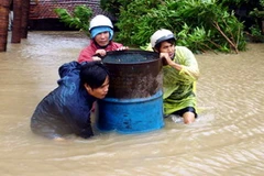 Người dân xã An Hiệp, huyện Tuy An, Phú Yên, phải dầm mình trong nước lũ. (Ảnh: Thế Lập/TTXVN)